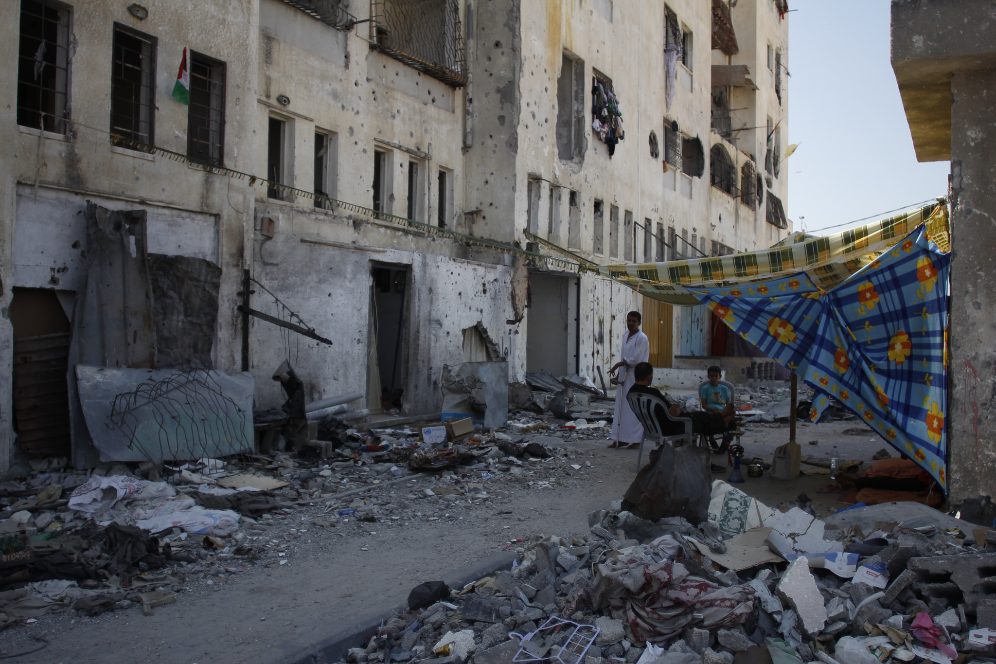 outside Omar's destroyed apartment building