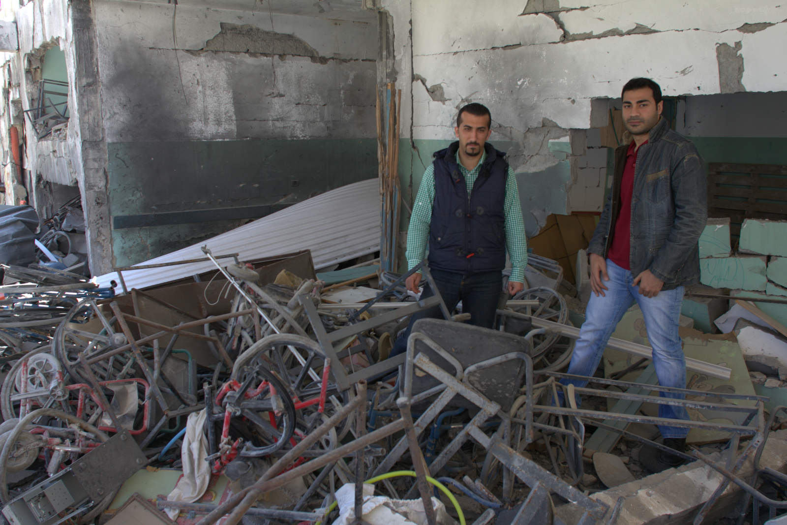 Mostafa Asi and Dr. Bassel Abu Warda in the rubble of the destroyed school