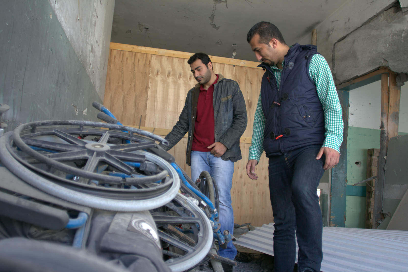 Dr. Bassel Abu Warda and Mostafa Asi surveying damaged wheelchairs