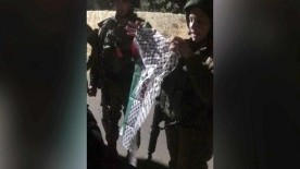 Israeli soldiers harass family who hung Palestinian flags on the fence of their home