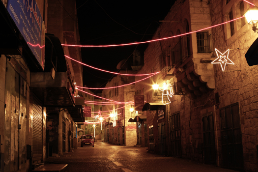 Christmas lights hang above a street in Bethlehem. (PHOTO: Firas Mukarker)