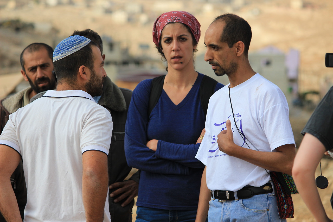 Activists and local residents prevent an Israeli settler from marching into the Palestinian town of At-Tuwani.
